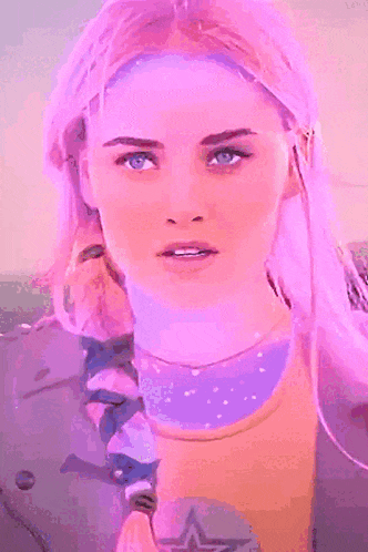 a woman with pink hair has her eyes closed and a braid in her hair