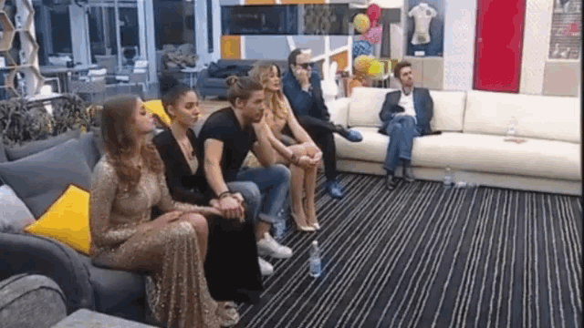 a group of people are sitting in a living room