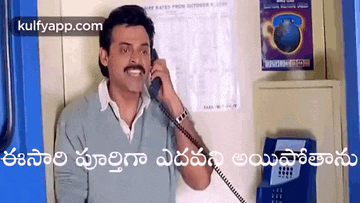 a man with a mustache is talking on a phone in a pay phone booth .