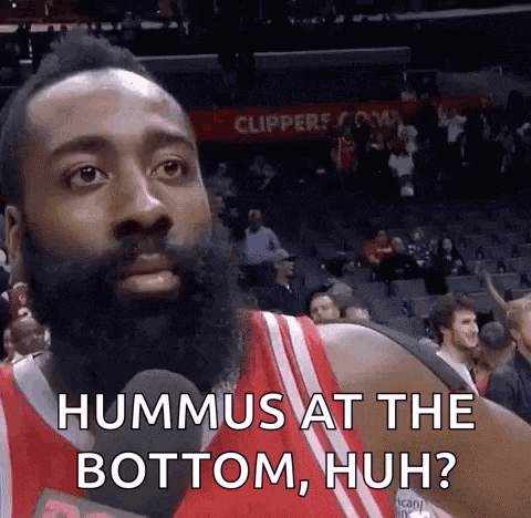a basketball player with a beard is talking into a microphone and says hummus at the bottom huh ?
