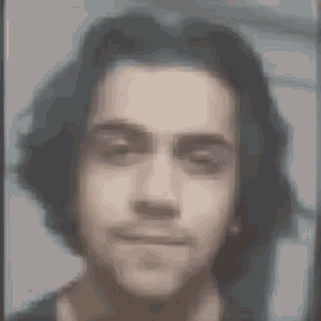 a close up of a man 's face with a blurry background .