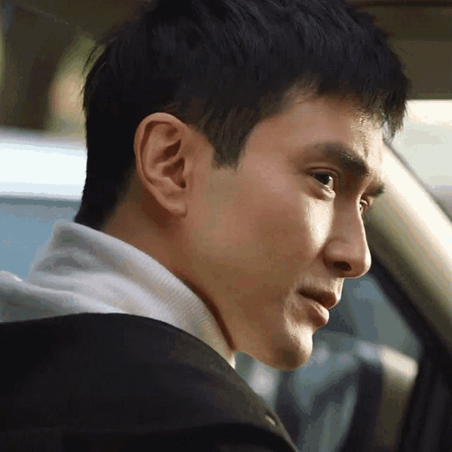 a close up of a man 's face in a car with his eyes closed