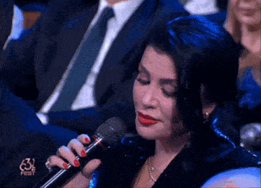 a woman singing into a microphone with fest written on the screen
