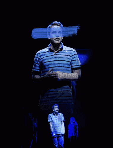 a man in a blue and white striped shirt is standing on a stage