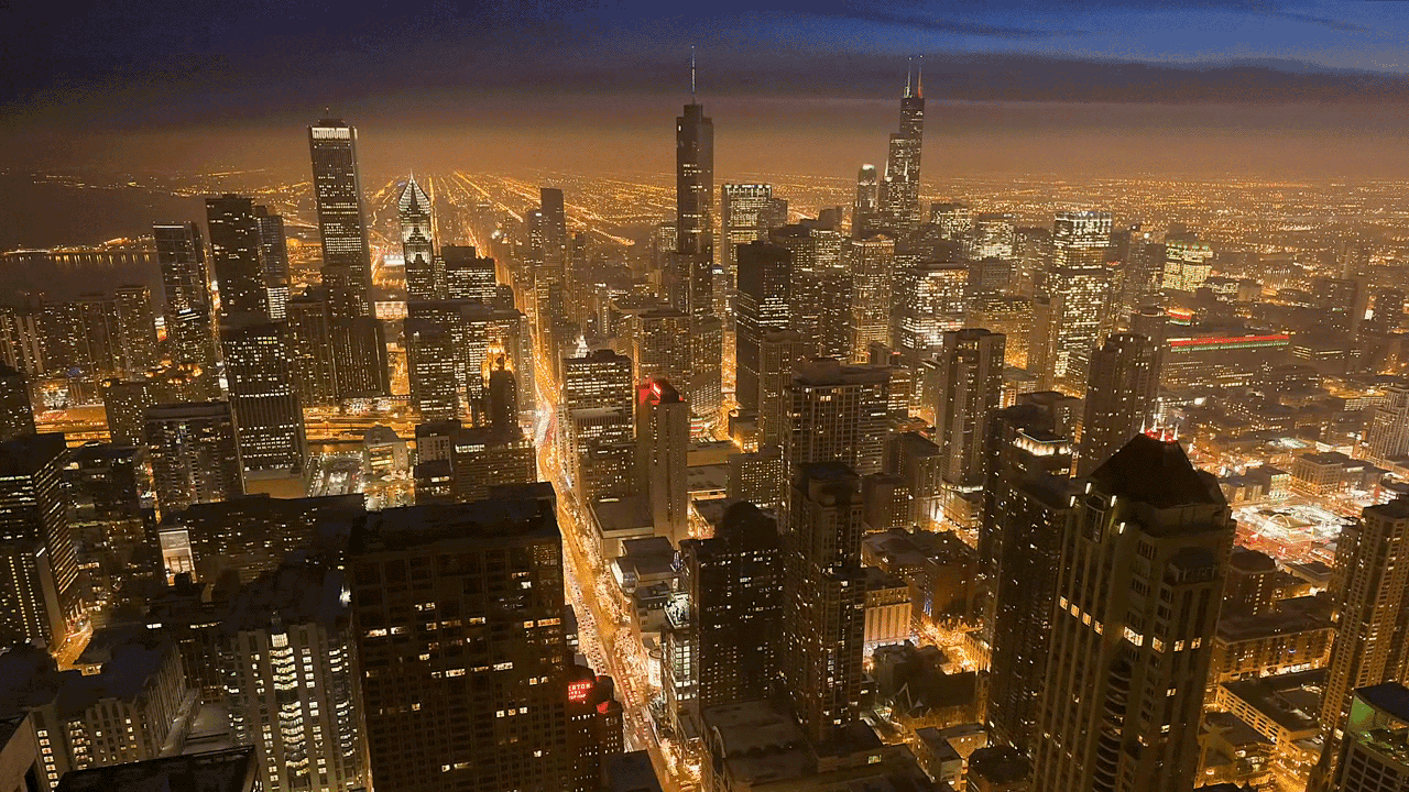 an aerial view of a city at night with a few buildings lit up