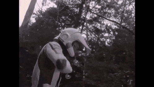 a black and white photo of a person wearing a helmet and gloves