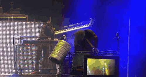 a pixelated image of a man playing drums with a barrel that says ' a ' on it