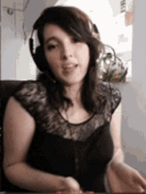 a woman wearing headphones is sitting at a desk .
