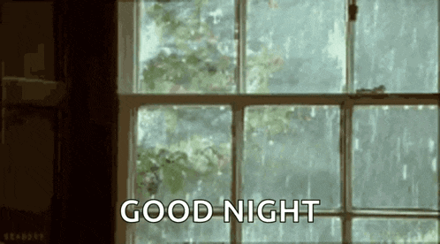 it is raining outside of a window and the words `` good night '' are written on the screen .