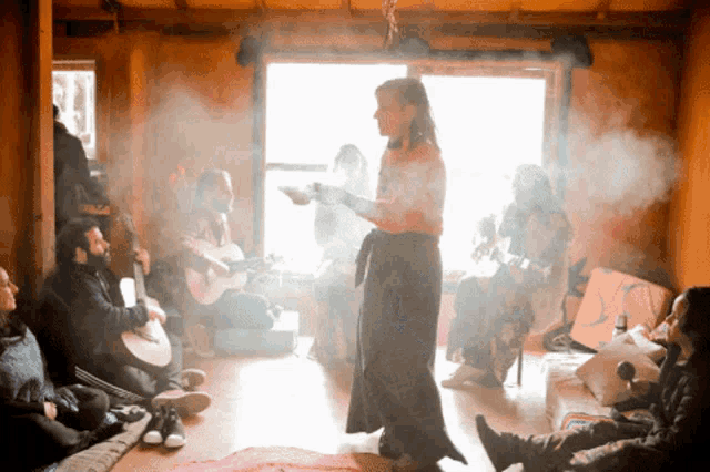 a woman is standing in front of a group of people