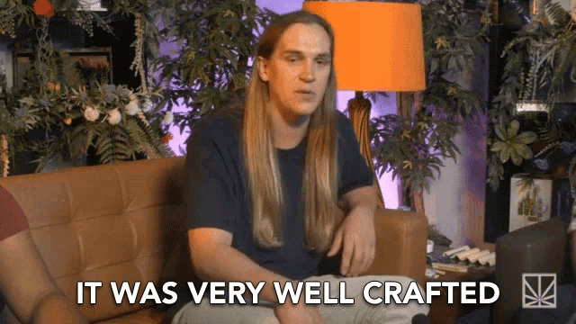 a man with long hair sits on a couch with the words it was very well crafted above him