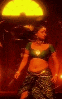 a woman in a green top and green skirt is dancing in front of a window