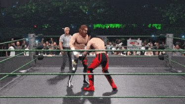 two wrestlers are in a ring with a sign that says $ 2 mil