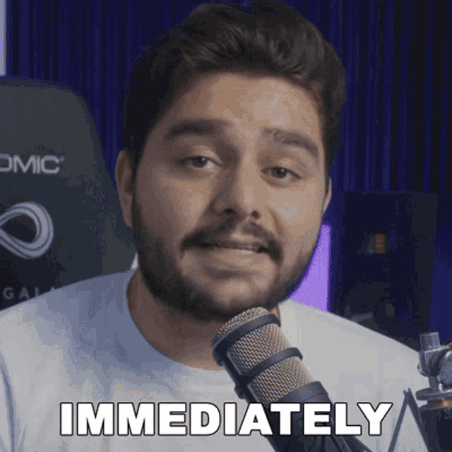 a man with a beard is talking into a microphone and the word immediately is on the screen