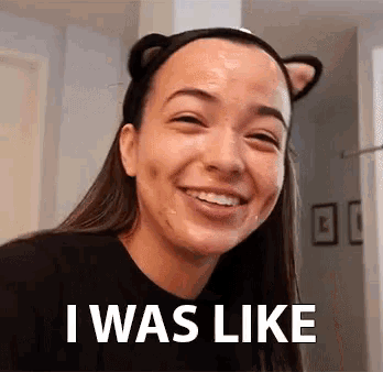 a woman wearing a cat ear headband is smiling and says `` i was like '' .