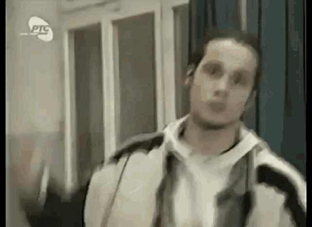 a man in a jacket is standing in front of a door .