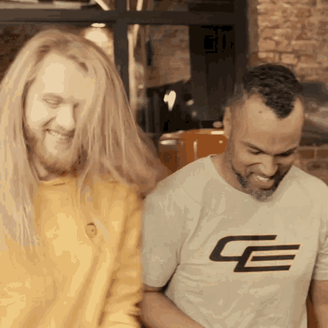 a man with long hair and a beard is wearing a shirt with the letter e on it