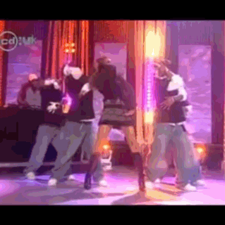 a group of people are dancing on a stage in front of a cd uk sign
