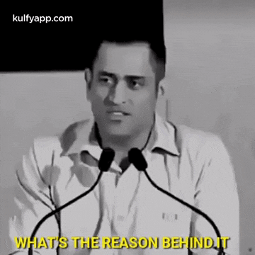 a man is giving a speech in front of two microphones and says what 's the reason behind it