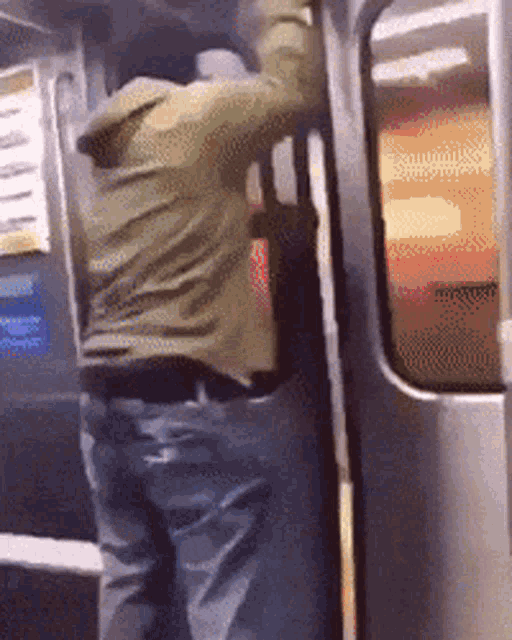 a man in a green jacket is getting off a subway train