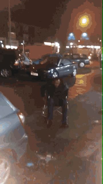 a man in a wheelchair is sitting in a parking lot