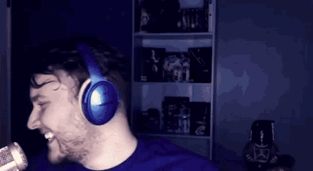 a man is wearing headphones and singing into a microphone .