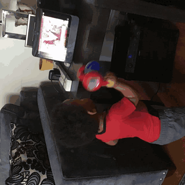 a child is playing with a toy while watching a tv show
