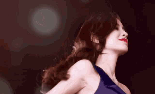 a woman in a blue dress with red lipstick is looking up