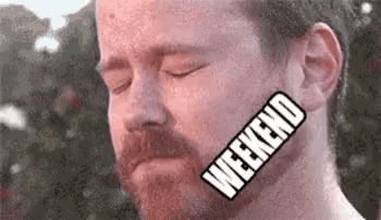 a man with a beard has a sticker on his neck that says `` weekend '' .