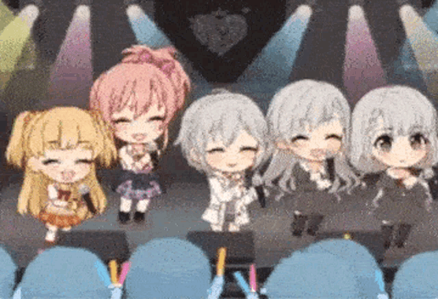a group of anime girls are standing on a stage holding microphones and smiling .