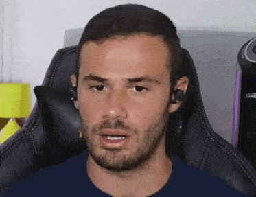 a man with a beard is wearing headphones and sitting in a chair