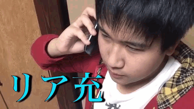 a young boy talking on a cell phone with the word リア 充 written below him