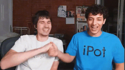 a man in a blue ipod t-shirt shakes hands with another man in a white shirt