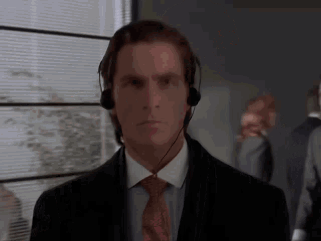 a man wearing a suit and tie is wearing headphones