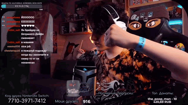 a man wearing headphones is playing a video game with a nintendo switch in the background