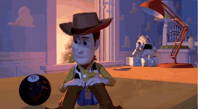 woody from toy story sits on the floor next to a black ball with the number 8 on it