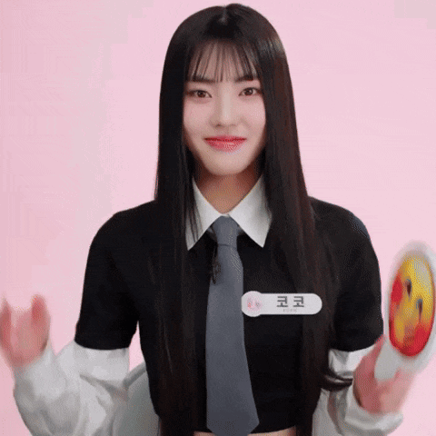 a girl wearing a black shirt and tie has a name tag that says " 코코 " on it