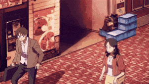 a man and a woman are walking down a brick sidewalk in front of a store .