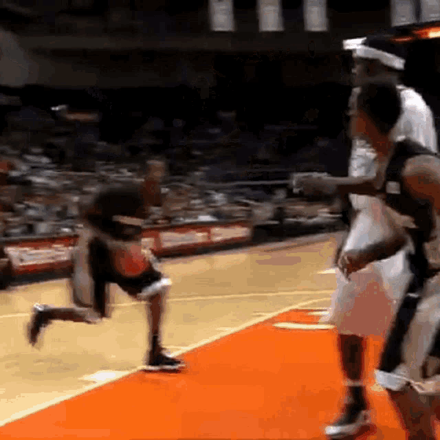 a group of basketball players are playing a game of basketball on a court