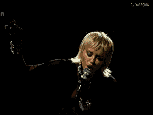 a gif of a woman singing into a microphone with the words cyrussgifs at the bottom