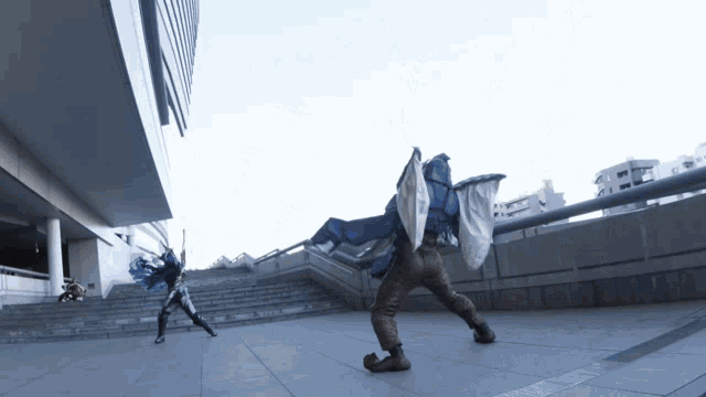 a man in a blue and white cape is fighting another man