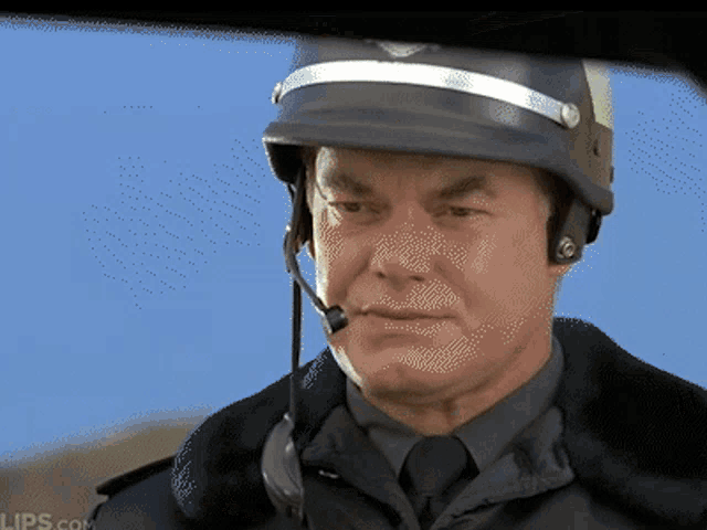 a man wearing a helmet and a microphone looks at the camera with lips.com in the corner