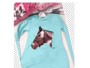 a blue shirt with a horse 's head on it .