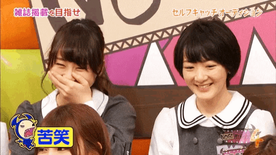two girls are laughing and one has a tag that says nogi on it