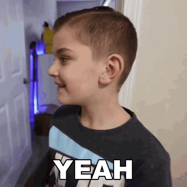 a young boy is wearing a shirt that says yeah on it