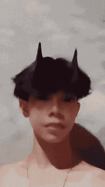 a young man with horns on his head without a shirt on