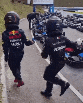 a man in a red bull racing suit is running down a street