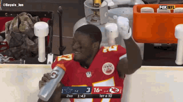 a football player with the number 7 on his jersey drinks water
