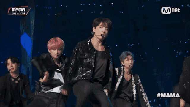 a group of young men are performing on a stage with the hashtag #mama