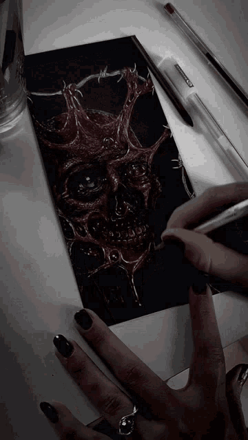 a person is drawing a skull with a pen that says bic on it